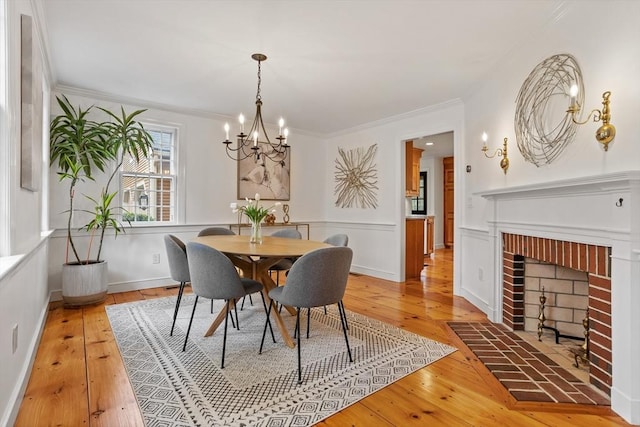 6 Shannon Cir, Westford, MA 01886 - dining area featuring a chandelier, light wood-style flooring, crown molding, a brick fireplace, and baseboards