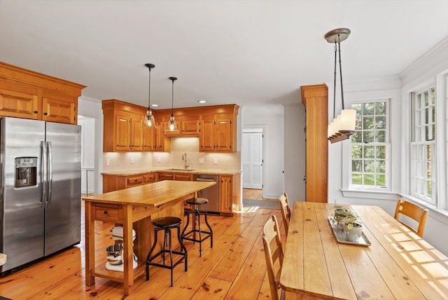 6 Shannon Cir, Westford, MA 01886 - kitchen featuring stainless steel appliances, a sink, light wood-style flooring, backsplash, and light countertops