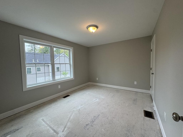 empty room featuring baseboards and visible vents