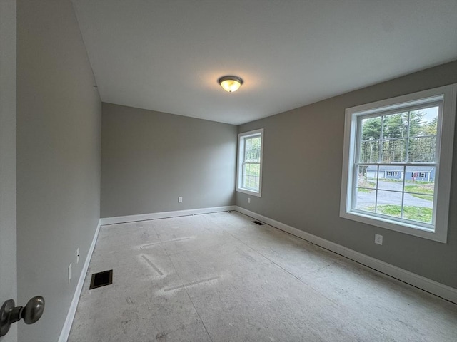 unfurnished room featuring baseboards and visible vents