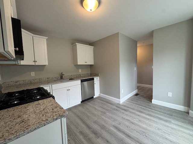 kitchen with baseboards, white cabinets, a sink, light wood-style flooring, and dishwasher