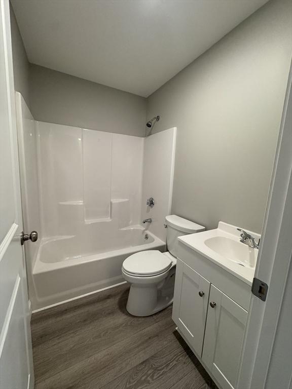full bathroom with vanity, toilet, wood finished floors, and  shower combination