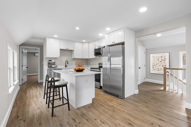 36-38 Madison St, Weymouth, MA 02189 - kitchen with appliances with stainless steel finishes, a kitchen bar, light countertops, a center island, and white cabinets