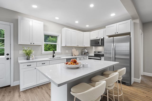 36-38 Madison St, Weymouth, MA 02189 - kitchen with appliances with stainless steel finishes, a kitchen bar, white cabinets, light countertops, and recessed lighting