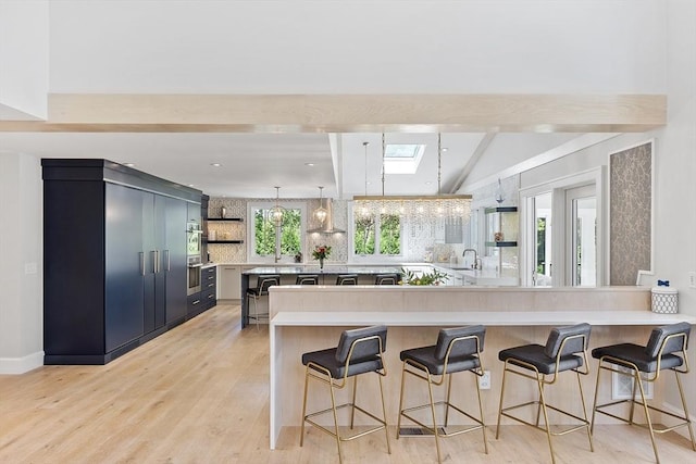 31 Alford Cir, Concord, MA 01742 - kitchen with beamed ceiling, a sink, light countertops, a breakfast bar, and open shelves