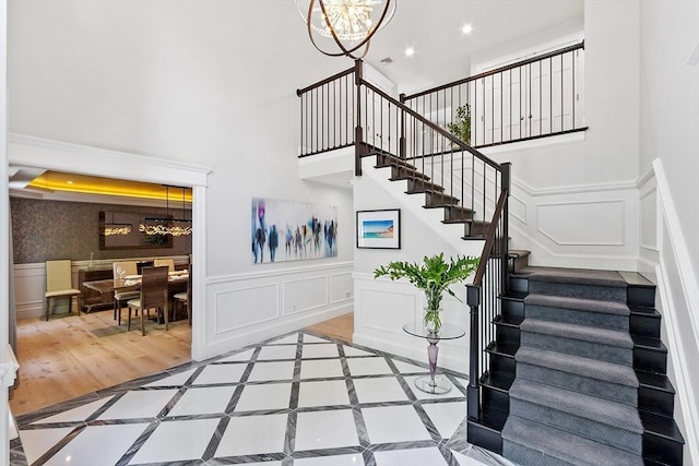 31 Alford Cir, Concord, MA 01742 - stairs with a decorative wall, a chandelier, wood finished floors, a high ceiling, and recessed lighting