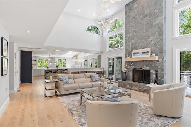 31 Alford Cir, Concord, MA 01742 - living area featuring healthy amount of natural light, a chandelier, wood finished floors, a fireplace, and a high ceiling