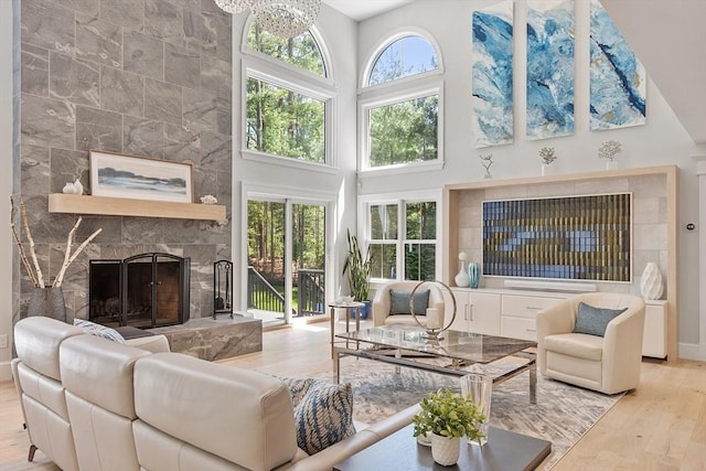 31 Alford Cir, Concord, MA 01742 - living area with wood finished floors, a fireplace, a towering ceiling, and baseboards