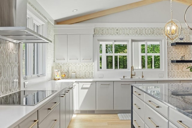 31 Alford Cir, Concord, MA 01742 - kitchen with wall chimney range hood, a sink, black electric stovetop, a chandelier, and white cabinets