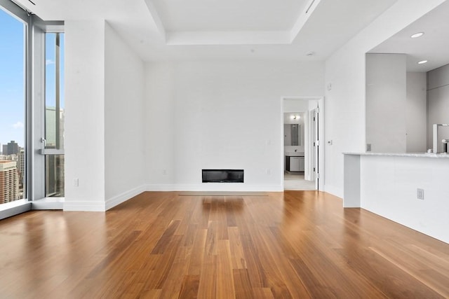 1 Dalton St Unit 3302, Boston, MA 02199 - unfurnished living room featuring wood finished floors, a glass covered fireplace, a raised ceiling, baseboards, and recessed lighting