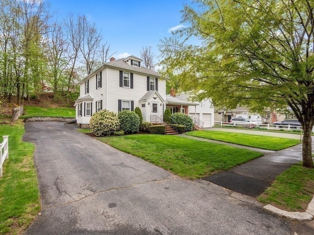 traditional style home featuring a garage, a front lawn, and driveway