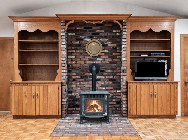 unfurnished living room featuring vaulted ceiling and a wood stove