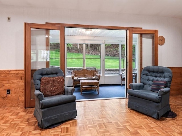 sitting room with wooden walls and a wainscoted wall