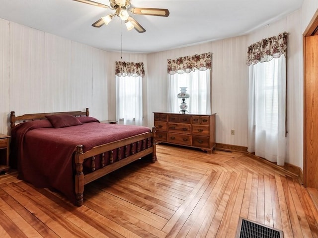 bedroom featuring ceiling fan, light wood finished floors, and visible vents