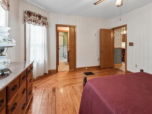 bedroom featuring baseboards, ceiling fan, visible vents, and wallpapered walls