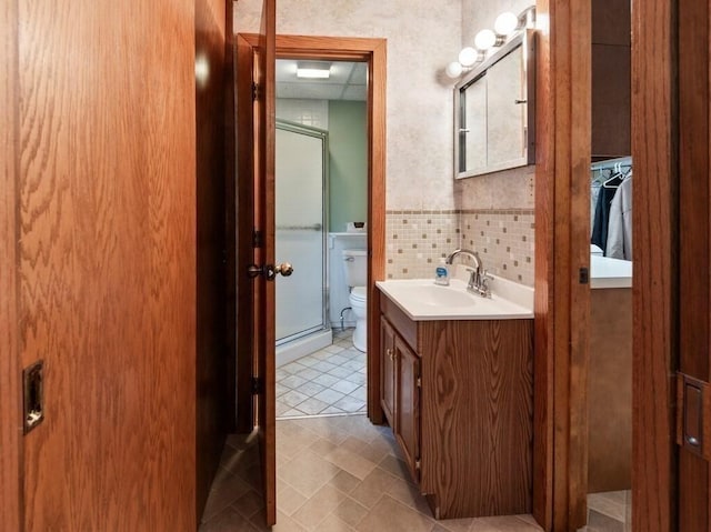 bathroom with a shower stall, vanity, and toilet