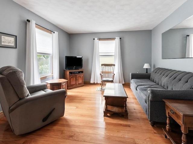 living room with light wood-style flooring and baseboards