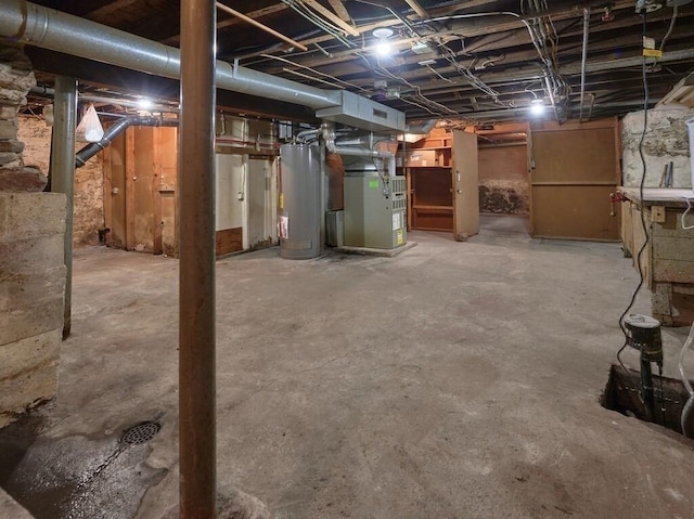 unfinished below grade area featuring heating unit and gas water heater
