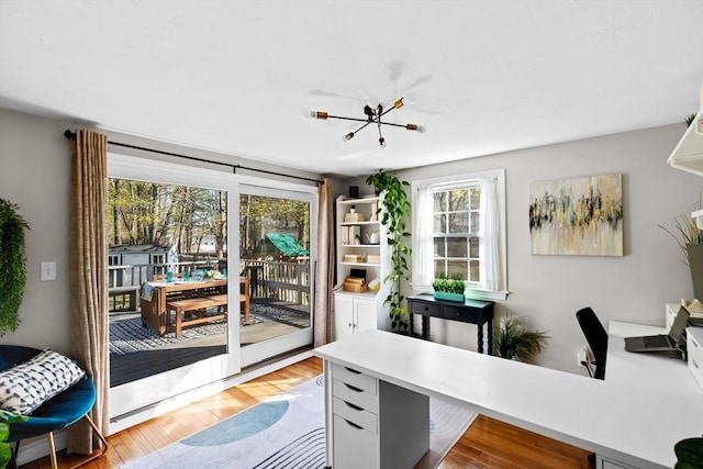 office area featuring an inviting chandelier and light wood-type flooring