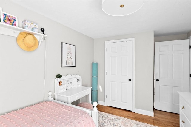 bedroom featuring baseboards and wood finished floors