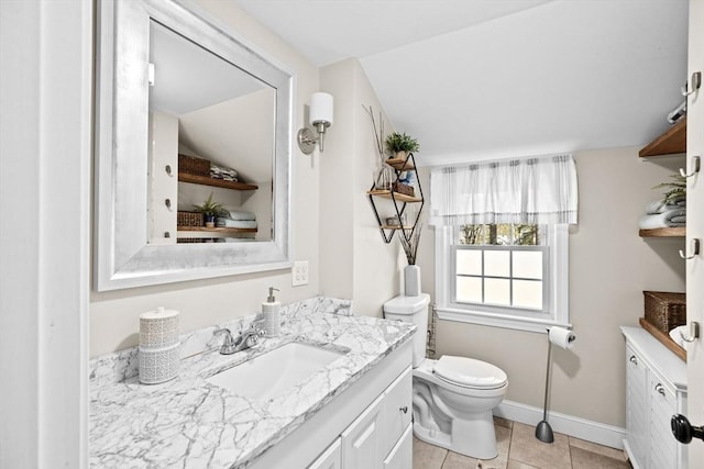 bathroom featuring toilet, tile patterned floors, baseboards, and vanity