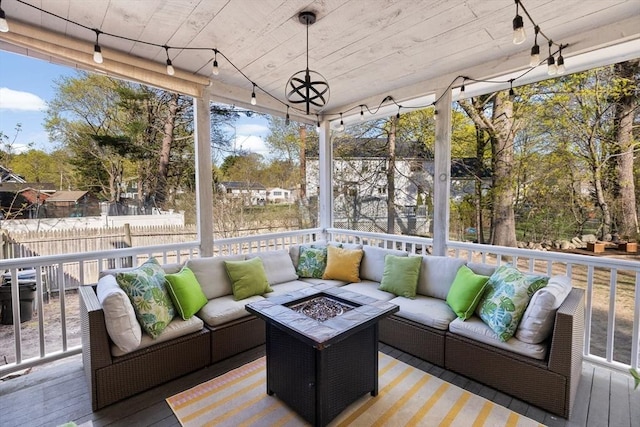 sunroom with an outdoor living space with a fire pit and a wealth of natural light