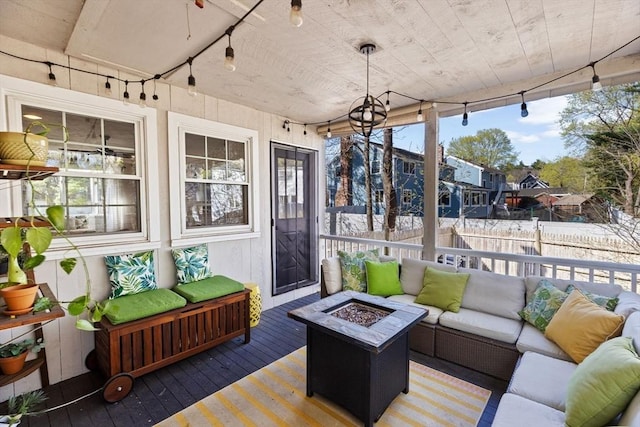 sunroom with an outdoor living space with a fire pit and rail lighting