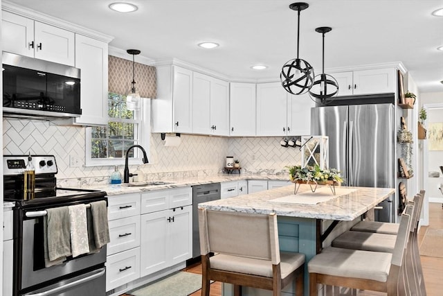 kitchen with decorative backsplash, stainless steel appliances, white cabinetry, and a sink