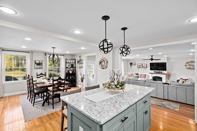 kitchen with light wood-style floors, a ceiling fan, recessed lighting, and a center island