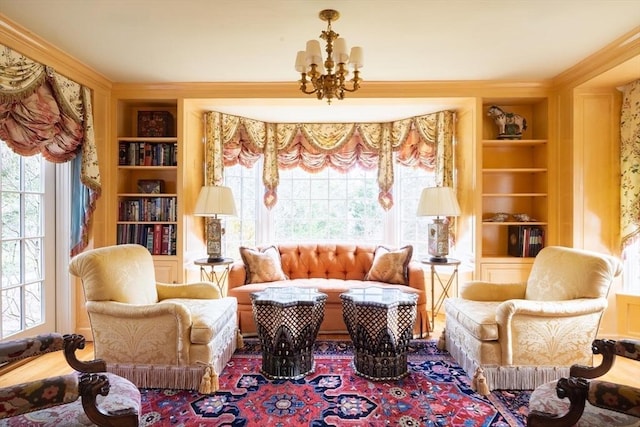 living area with ornamental molding, built in features, and a notable chandelier