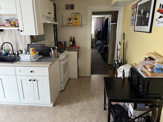 72 Wright St, Stoneham, MA 02180 - kitchen with under cabinet range hood, white cabinets, a sink, white gas stove, and light countertops