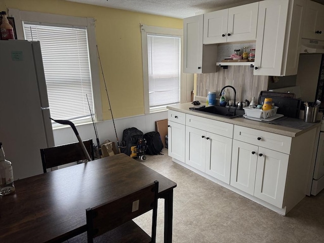 72 Wright St, Stoneham, MA 02180 - kitchen with a sink, freestanding refrigerator, white cabinetry, open shelves, and a textured ceiling