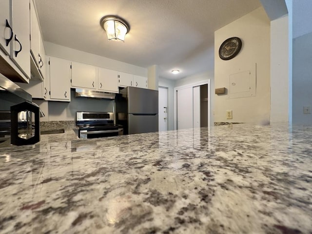 kitchen featuring stainless steel appliances, white cabinetry, under cabinet range hood, and light stone counters