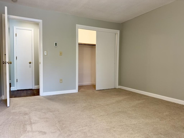 unfurnished bedroom with a closet, carpet flooring, and baseboards