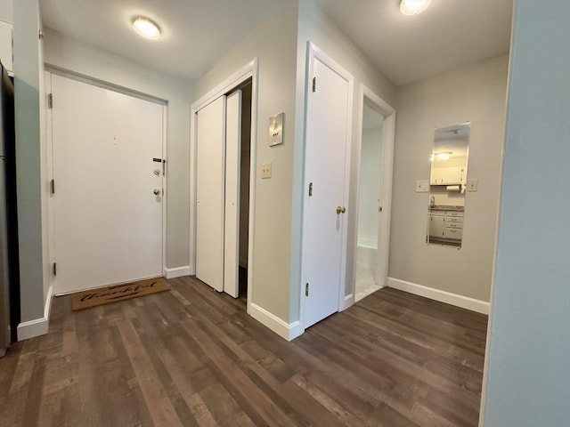 corridor featuring dark wood-style floors and baseboards