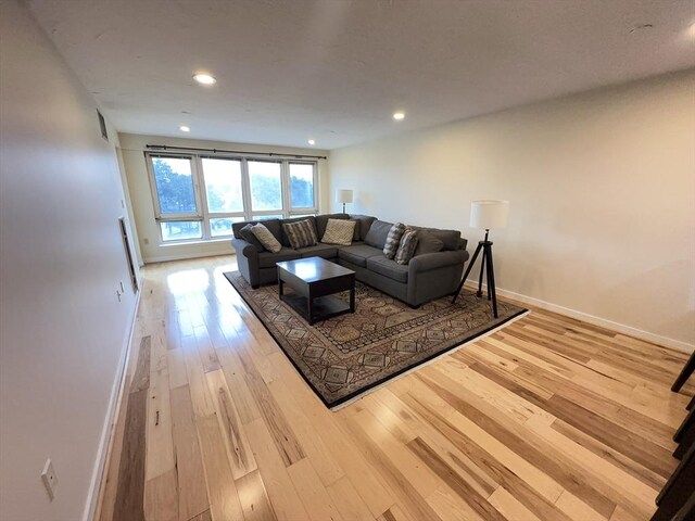 living area featuring recessed lighting, baseboards, and hardwood / wood-style flooring