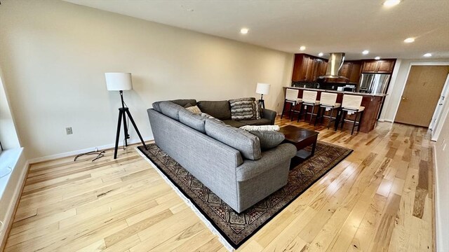 living area with recessed lighting, baseboards, and light wood-style floors