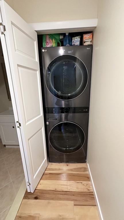 1001 Marina Dr Unit 213, Quincy, MA 02171 - laundry area featuring stacked washer / drying machine and light wood-style flooring