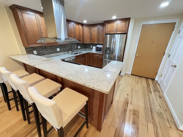 1001 Marina Dr Unit 213, Quincy, MA 02171 - kitchen featuring stainless steel appliances, a sink, island exhaust hood, a peninsula, and light wood finished floors