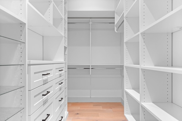 walk in closet with light hardwood / wood-style flooring