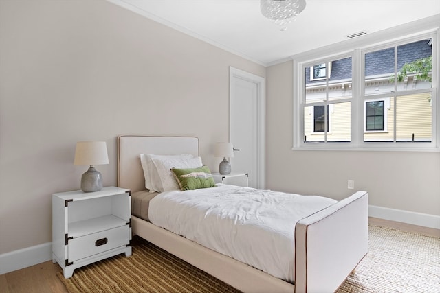 bedroom featuring light hardwood / wood-style flooring and crown molding