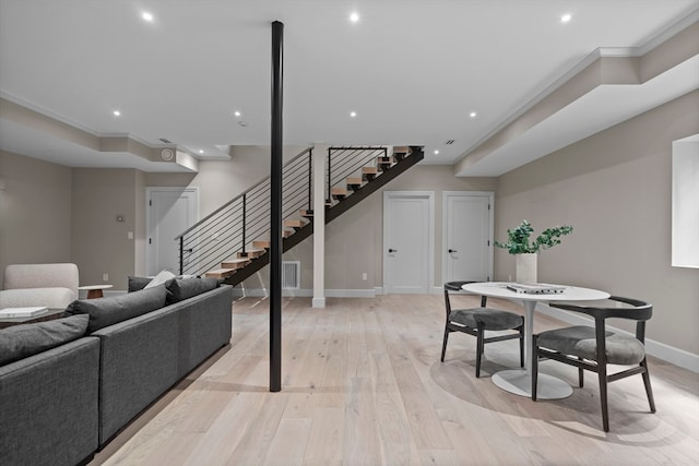 living room featuring light wood-type flooring and ornamental molding