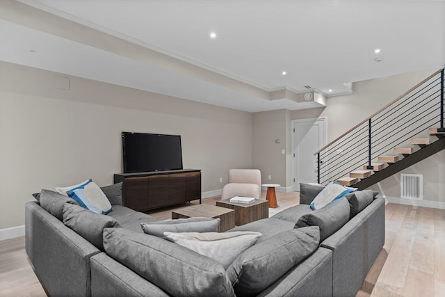 living room with light hardwood / wood-style flooring and crown molding