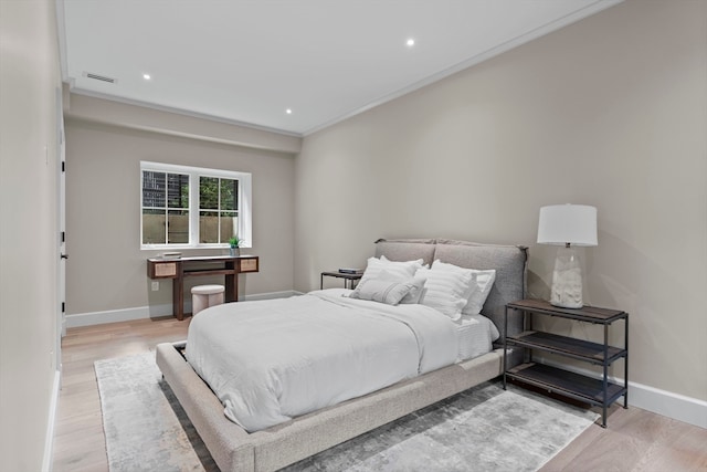 bedroom featuring light hardwood / wood-style flooring and ornamental molding