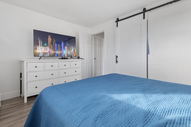 bedroom with hardwood / wood-style floors and a barn door