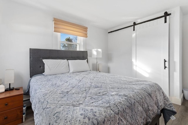 bedroom featuring a barn door and wood-type flooring