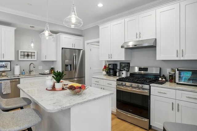 132 High St Unit B, Newburyport, MA 01950 - kitchen featuring appliances with stainless steel finishes, under cabinet range hood, ornamental molding, white cabinets, and a kitchen bar