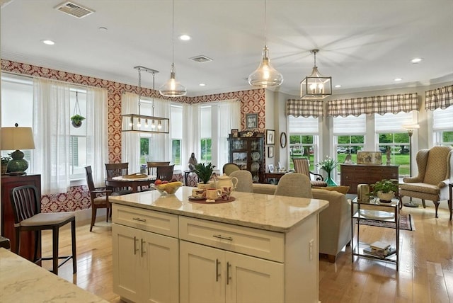 132 High St Unit B, Newburyport, MA 01950 - kitchen featuring ornamental molding, light wood-type flooring, wallpapered walls, light stone countertops, and hanging light fixtures