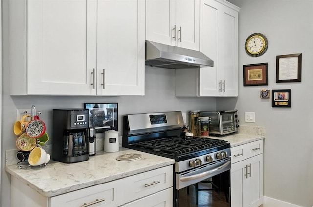 132 High St Unit B, Newburyport, MA 01950 - kitchen with stainless steel range with gas stovetop, ventilation hood, white cabinetry, and light stone counters