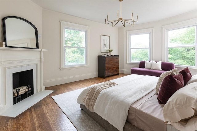 151 Salisbury Rd, Brookline, MA 02445 - bedroom with a chandelier, multiple windows, wood finished floors, and a fireplace